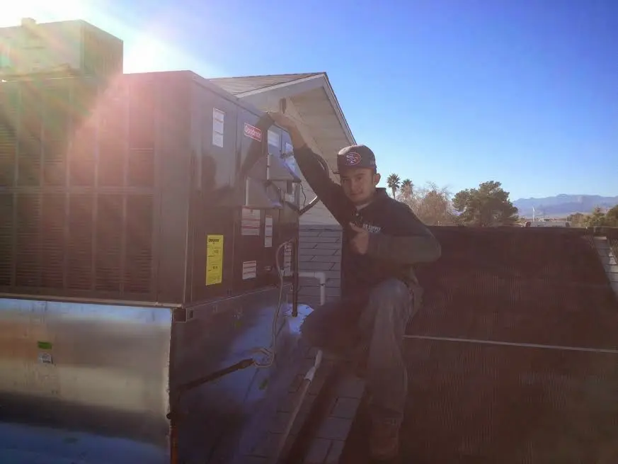 HVAC technician performing Boiler Repair on a rooftop unit in Prescott